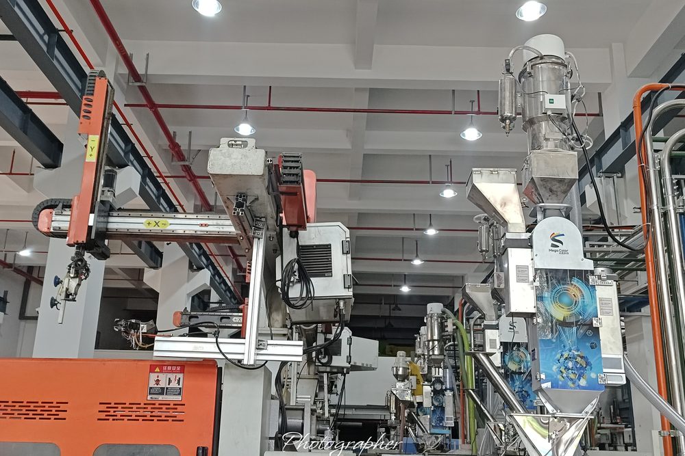A 4th Generation dual-material unit above the machine hopper, with separate chambers for masterbatch and additive