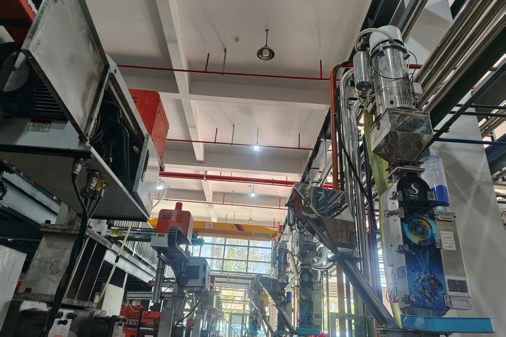 The dosing machine shares the space above the press with the robot arm and conveying lines
